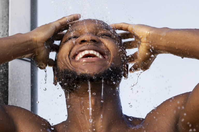 low-angle-man-taking-shower-portrait-768x512 Banho gelado ajuda a emagrecer? Descubra os 4 benefícios surpreendentes! Perder Peso  